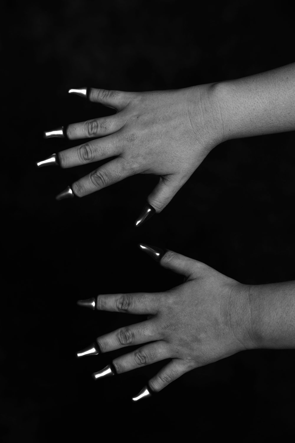 After: The same hands with metal claw implants on every fingertip