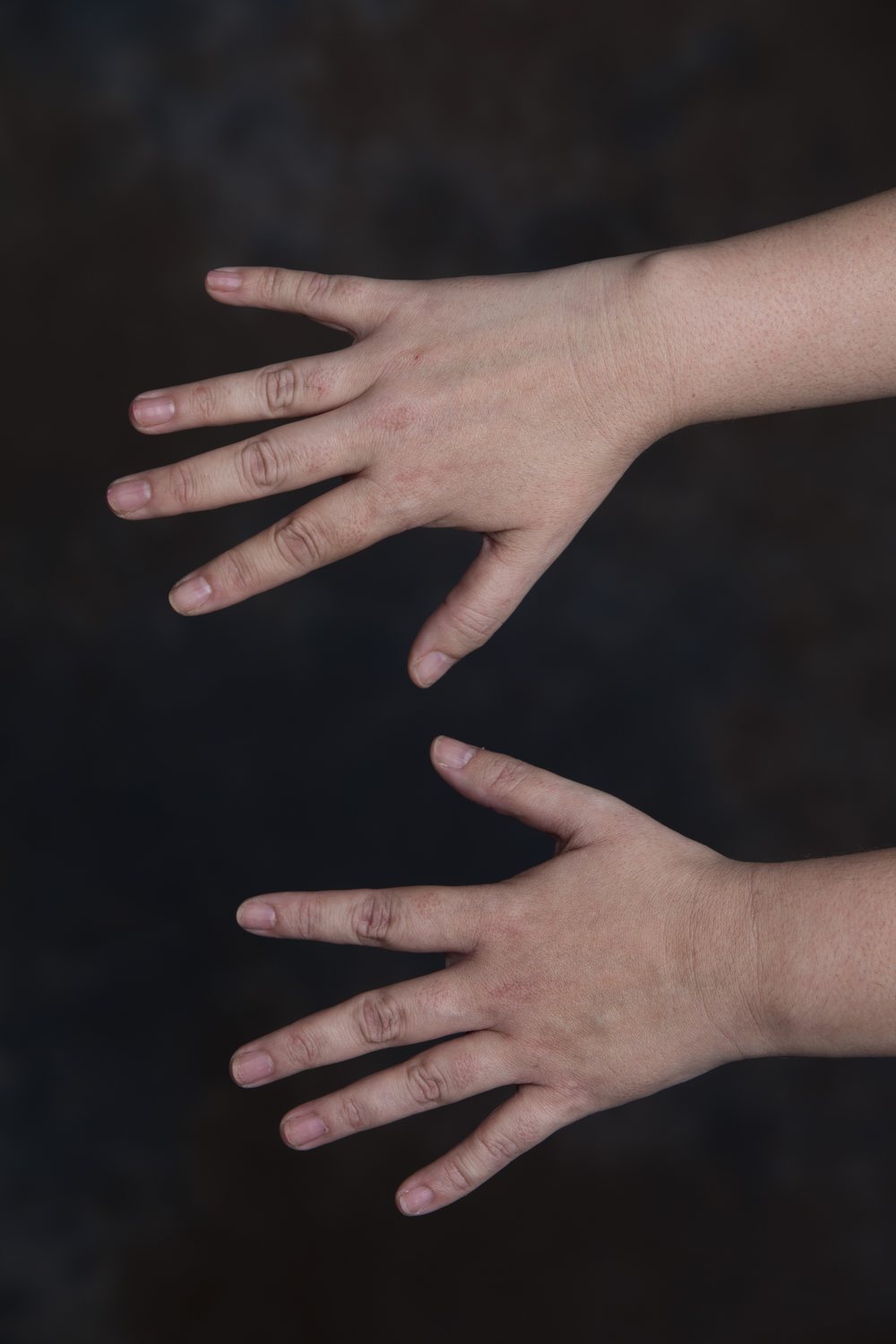 Before: Original photo of two hands on a dark background