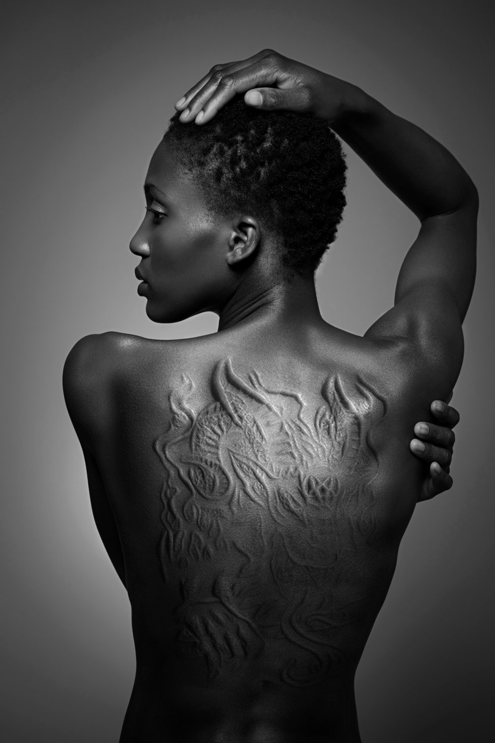 After: The same photo with raised scarification designs across her back