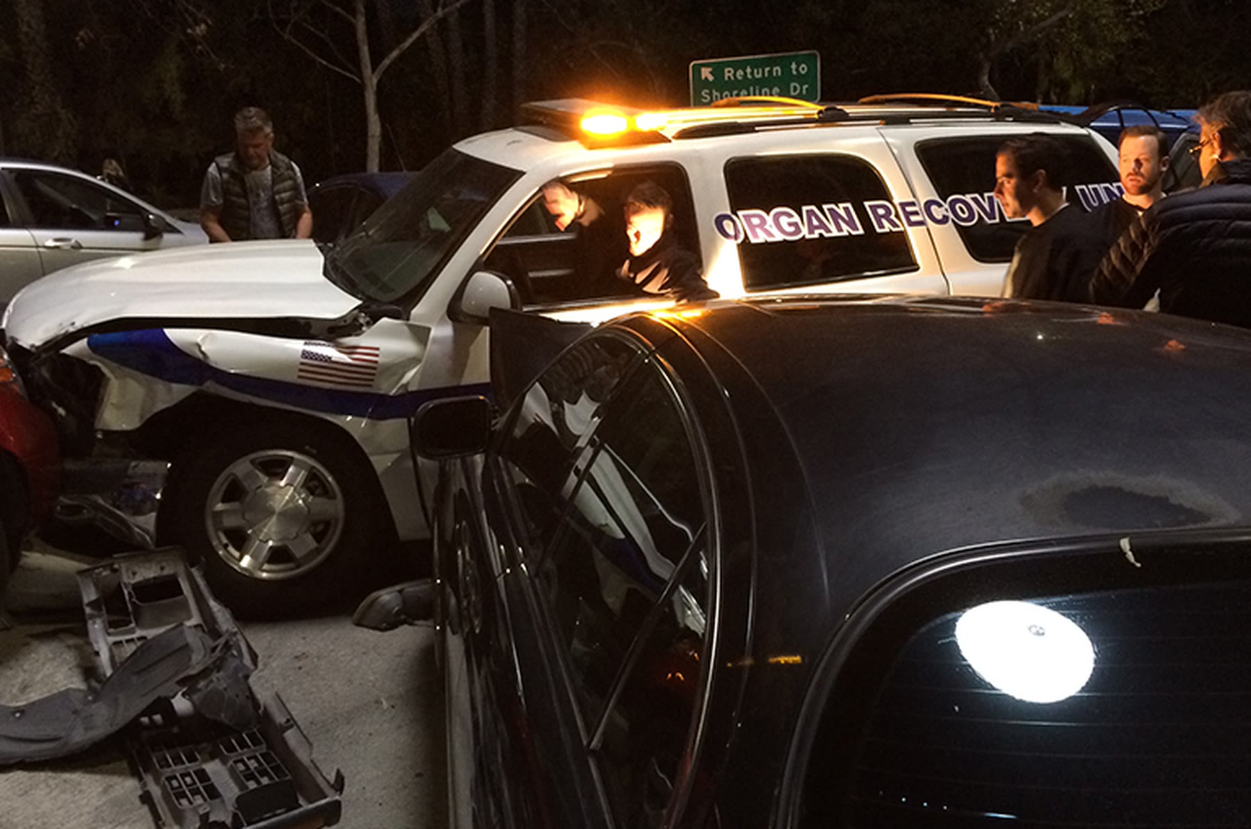 Wrecked car at night with an emergency vehicle